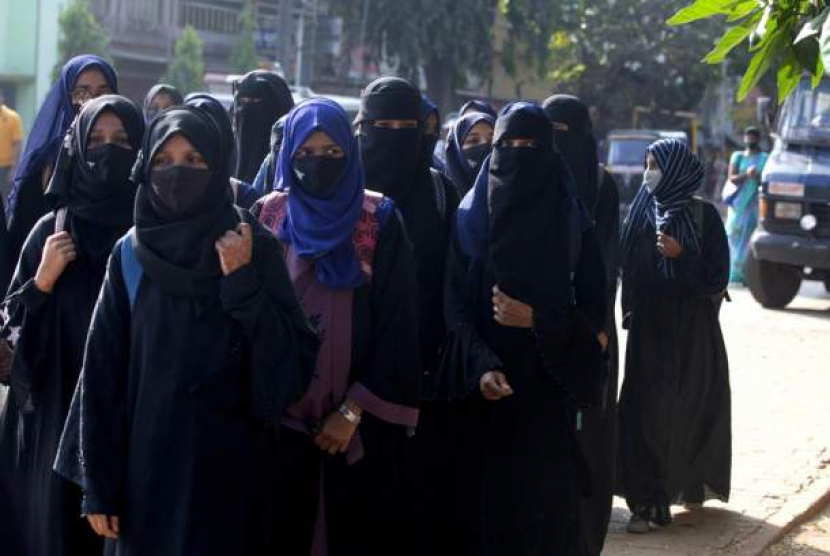 Mahasiswi yang dilarang memasuki kelas mereka karena berhijab, berjalan menuju kampus mereka di Udupi, India, Jumat (4/2). 