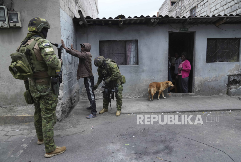 Tentara berhenti dan mencari senjata di pejalan kaki saat mereka berpatroli di daerah pemukiman di utara Quito, Ekuador, Kamis, (11/1/2024).