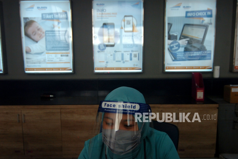 Petugas menggunakan penutup wajah duduk di tempat pembelian tiket saat persiapan pengoperasian KA Kaligung di Stasiun Tegal, Jawa Tengah (Jateng). Masih ada beberapa daerah di Jateng yang angka kasus Covid-19 masih tinggi.