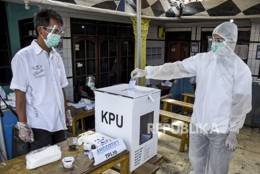 Petugas KPPS mengenakan alat pelindung diri (APD) dan pakaian hazmat memasukkan surat suara di TPS 10 Pangauban, Kecamatan Katapang, Kabupaten Bandung, Rabu (9/12). Komisi Pemilihan Umum (KPU) Kabupaten Bandung menggelar Pemilihan Bupati 2020 dengan menerapkan protokol kesehatan pencegahan Covid-19 di 6.874 TPS dengan jumlah Daftar Pemilih Tetap (DPT) sebanyak 2.356.412 pemilih. Foto: Abdan Syakura/Republika