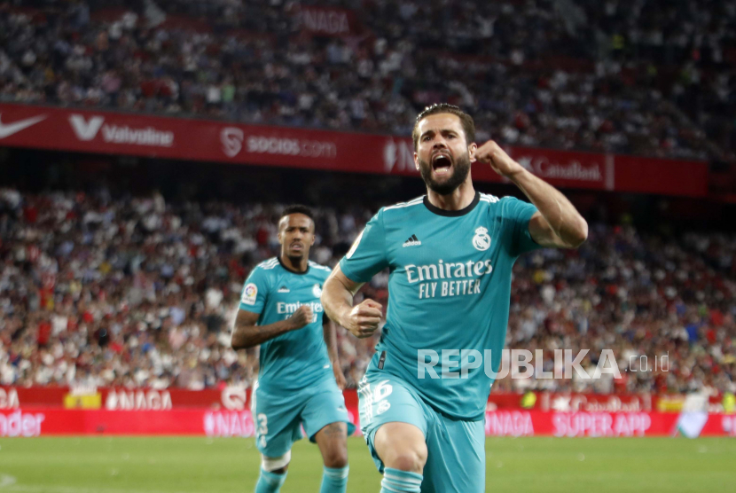 Pemain Real Madrid Nacho merayakan setelah mencetak gol kedua timnya selama pertandingan sepak bola La Liga Spanyol antara Sevilla dan Real Madrid di stadion Ramon Sanchez Pizjuan, di Seville, Spanyol, Senin (18/4/2022).