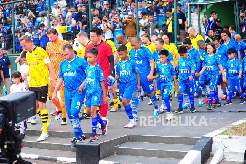 Para pemain Persib All Stars dan Borussia Dortmund (BVB) Legends memasuki lapangan saat laga persahabatan di Stadion Siliwangi, Kota Bandung, Ahad (10/9/2023). 