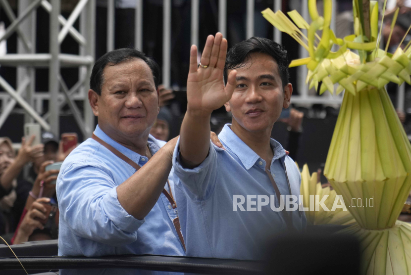 Presidential candidate Prabowo Subianto, left, and his running mate Gibran Rakabuming Raka, the eldest son of President Joko Widodo, greet supporters upon arrival to register their candidacy to run in the 2024 election, at the General Election Commission building in Jakarta, Indonesia, Wednesday, Oct. 25, 2023. The world