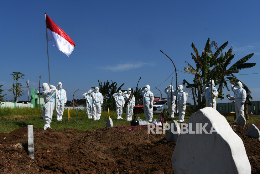 Sejumlah relawan pemakaman jenazah protokol COVID-19 dengan mengenakan Alat Pelindung Diri (APD) melakukan upacara bendera dalam rangka peringatan Hari Ulang Tahun ke-76 Proklamasi Kemerdekaan RI di Pemakaman Pagu Indah Kota Madiun, Jawa Timur, Ahad (15/8/2021). Para relawan pemakaman jenazah tersebut terdiri dari unsur Palang Merah Indonesia (PMI), Badan Penanggulangan Bencana Daerah (BPBD) dan Puskesmas. 