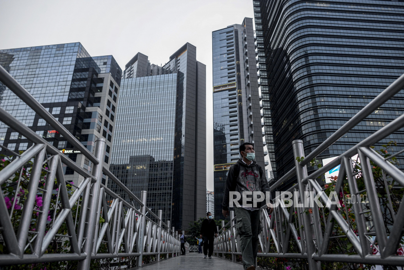 Pejalan kaki melintas JPO dengan latar belakang gedung-gedung di kawasan Sudirman, Jakarta, Rabu (5/8). Gubernur DKI Jakarta Anies Baswedan kembali menerapkan PSBB secara total mulai Senin (14/9).