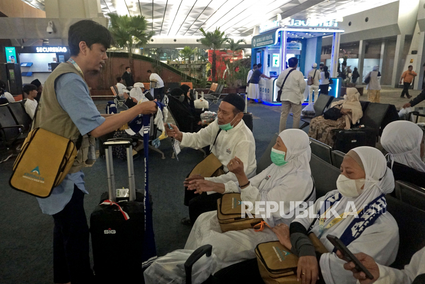 Team leader dari Abhinaya PT Dava Tour & Travel berbincang dengan jamaah umroh saat menunggu keberangkatan di Terminal 3 Bandara Internasional Soekarno-Hatta, Tangerang, Banten, Sabtu (29/4/2023). 