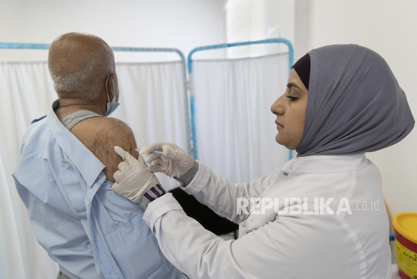 Seorang petugas kesehatan memberikan dosis vaksin Oxford-AstraZeneca COVID-19 kepada seorang pria Palestina selama kampanye vaksinasi, di kota Ramallah, Tepi Barat, Minggu, 6 Juni 2021.