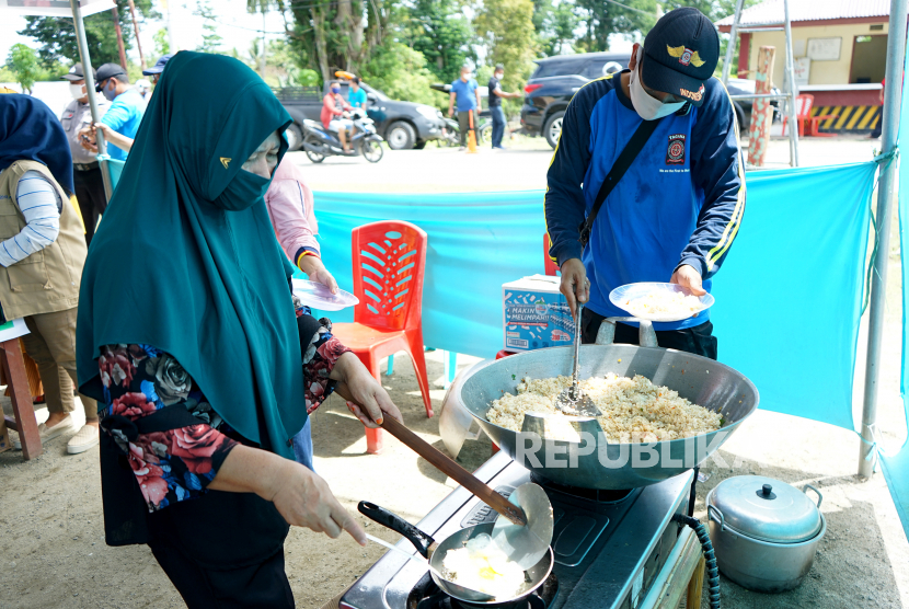 Anggota Tagana memasak makanan untuk korban banjir. ilustrasi