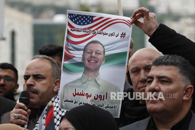  Seorang pria mengangkat foto mendiang penerbang AS Aaron Bushnell, yang meninggal setelah membakar dirinya di luar kedutaan Israel di Washington DC, AS pada 27 Februari 2024.
