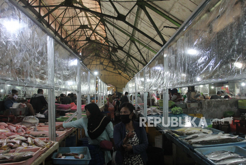 Warga beraktivitas di Pasar Ikan Pabean Surabaya, Jawa Timur, Senin (22/6/2020). Pasar tersebut menerapkan protokol pencegahan penularan COVID-19 seperti penyekat plastik di lapak pedagang, cuci tangan, jaga jarak dan kewajiban memakai masker bagi warga yang beraktivitas di pasar itu untuk memutus penularan COVID-19. ANTARA FOTO/Didik Suhartono/hp.