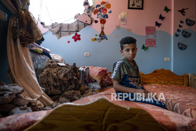 Ibrahim Al-Masri, 10, duduk untuk potret di kamar tidurnya yang rusak ketika serangan udara menghancurkan gedung tetangga sebelum gencatan senjata yang menghentikan perang 11 hari antara penguasa Hamas Gaza dan Israel, Rabu, 26 Mei 2021 , di Beit Hanoun, Jalur Gaza.