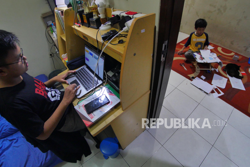 Kakak beradik Rakean Ahmad (kiri) dan Rahadian Ahmad (kanan) mengerjakan tugas sekolah di kediamannya di Bandung, Rabu (18/3). 