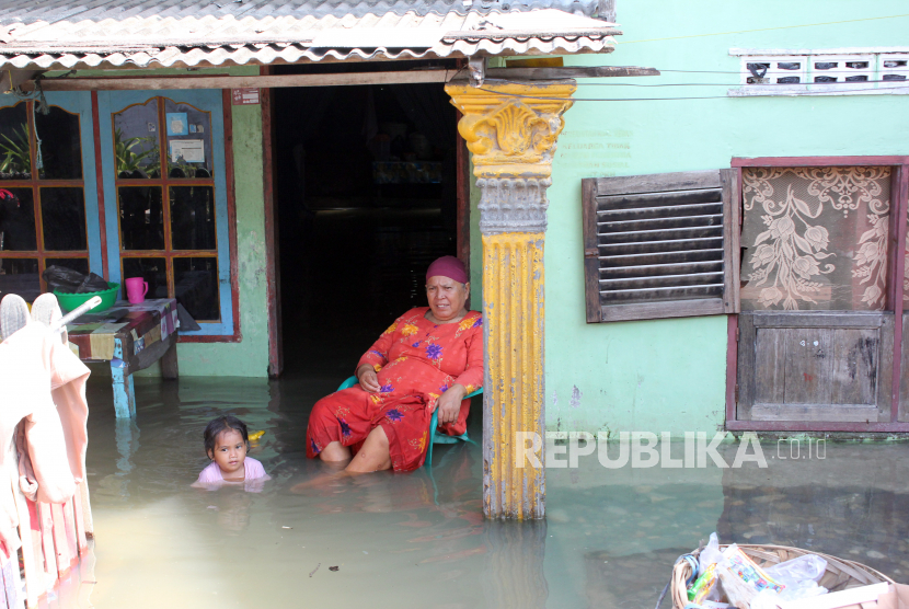 Warga duduk di depan rumahnya yang tergenang banjir. BPBD Medan mendirikan posko luapan Sungai Deli akibat banjir bandang.