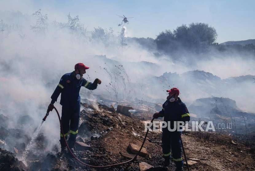 Petugas mencoba memadamkan api di kawasan Koropi, Athena bagian timur, Yunani, Rabu (19/6/2024).