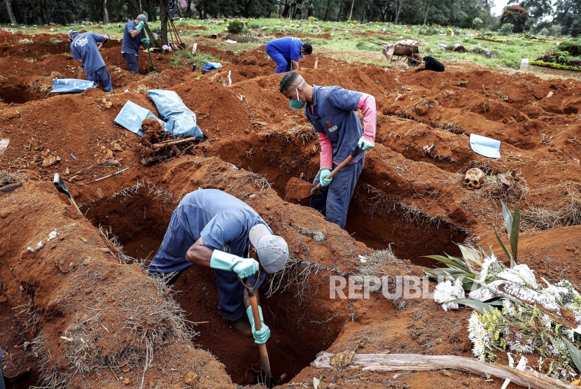 Petugas pemakaman Vila Formosa saat menggali kuburan lama untuk membuka ruang baru bagi mereka yang telah meninggal karena virus Corona di Sao Paulo, Brasil. Hingga Jumat (10/7), total kasus Covid-19 di Brasil mencapai 1.800.827 dengan total kematian 70.398. 