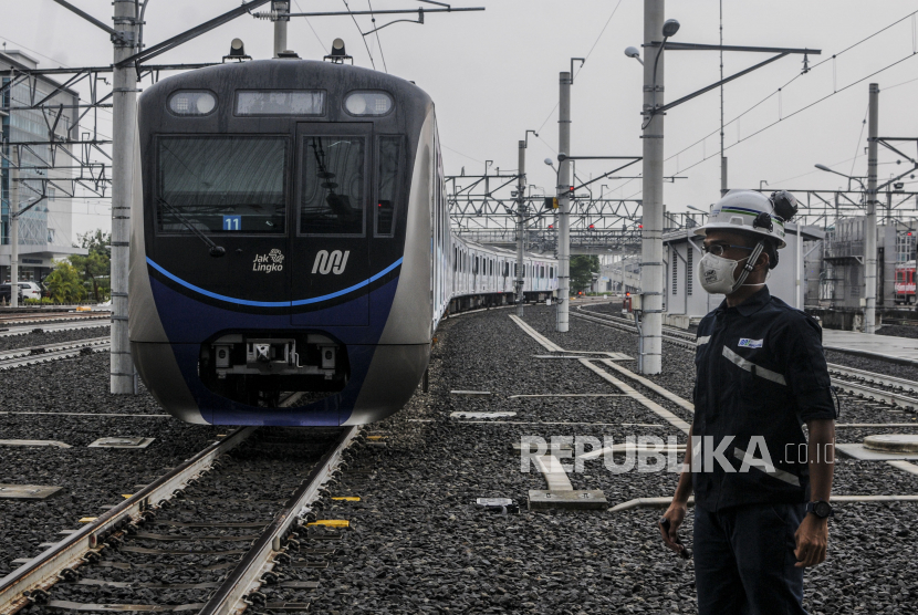 Petugas berjalan di dekat rangkaian MRT yang terparkir di Depo MRT Lebak Bulus, Jakarta Selatan, Kamis (31/3/2022). 