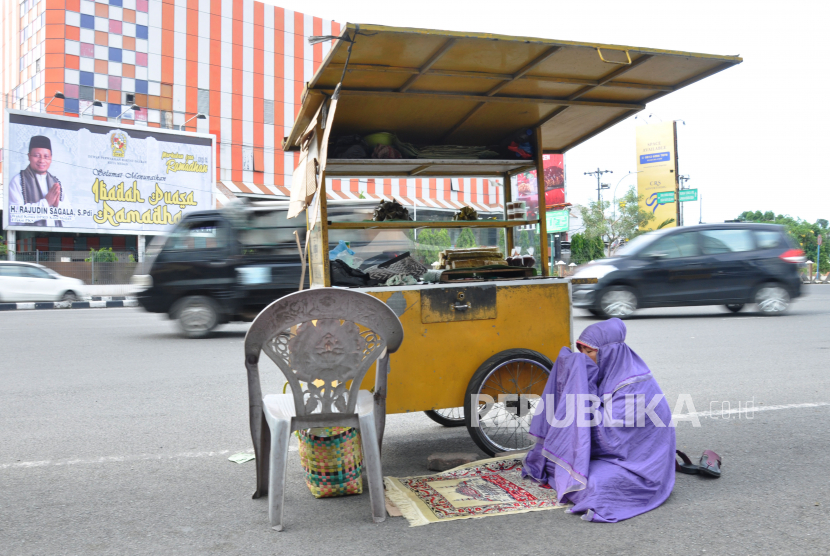 Seorang penjual lemang di sela menunaikan shalat Ashar sambil menunggu pembeli di kawasan Jalan Gatot Subroto Medan, Sumatera Utara, Selasa (5/5). Bank Indonesia (BI) memprediksi pertumbuhan ekonomi Sumut pada tahun ini hanya sebesar 1,2 persen sampai 1,6 persen. Prediksi itu kalau pandemi Covid-19 berlangsung hingga akhir tahun.