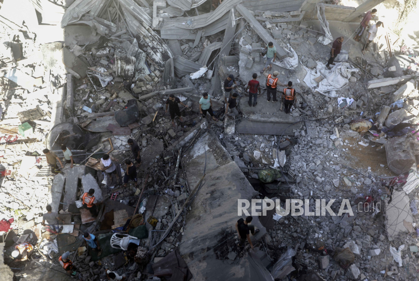Warga Palestina mencari korban selamat di bawah reruntuhan bangunan yang hancur akibat serangan udara Israel di kamp pengungsi Khan Younis, Jalur Gaza selatan, Senin, 6 November 2023.