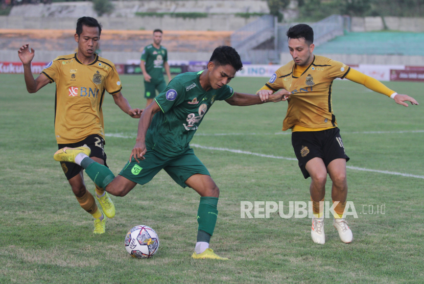 Pesepak bola Persebaya Marselino Ferdinan (tengah) saat mencoba melewati dua pesepak bola Bhayangkara FC Adam Ahmad Najem (kanan) dan Wahyu Subo Seto (kiri) pada pertandingan Liga 1 di Stadion Gelora Joko Samudro, Gresik, Jawa Timur, Senin (23/1/2023). Persebaya mengalahkan Bhayangkara FC dengan skor 2-1. 