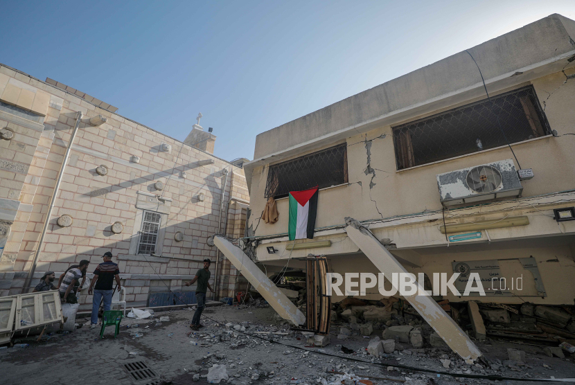 Warga Palestina memeriksa kerusakan di Gereja Ortodoks Yunani Saint Porphyrius menyusul serangan udara semalam di Gaza, 20 Oktober 2023. Setidaknya 18 orang meninggal.