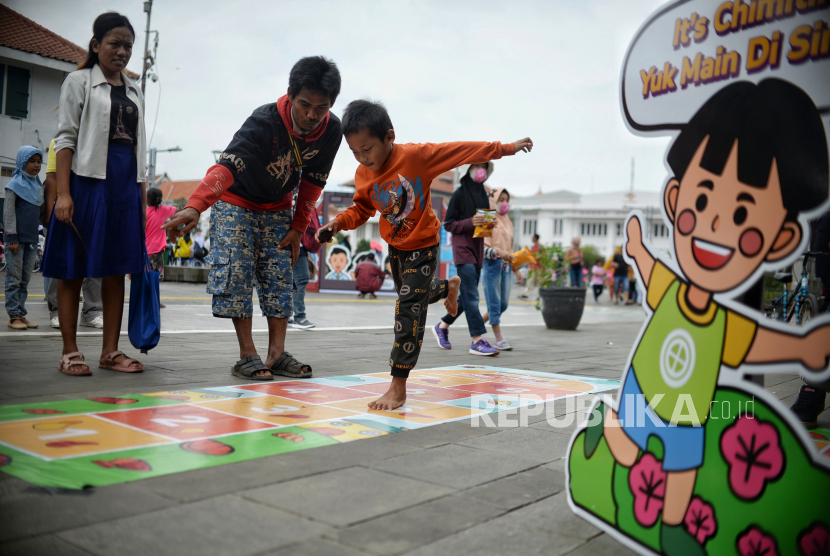 Anak memainkan permainan tradisional engklek di kawasan Kota Tua Jakarta. Kawasan Kota Tua, Jakbar, dipadati wisatawan pada hari pertama tahun 2023.