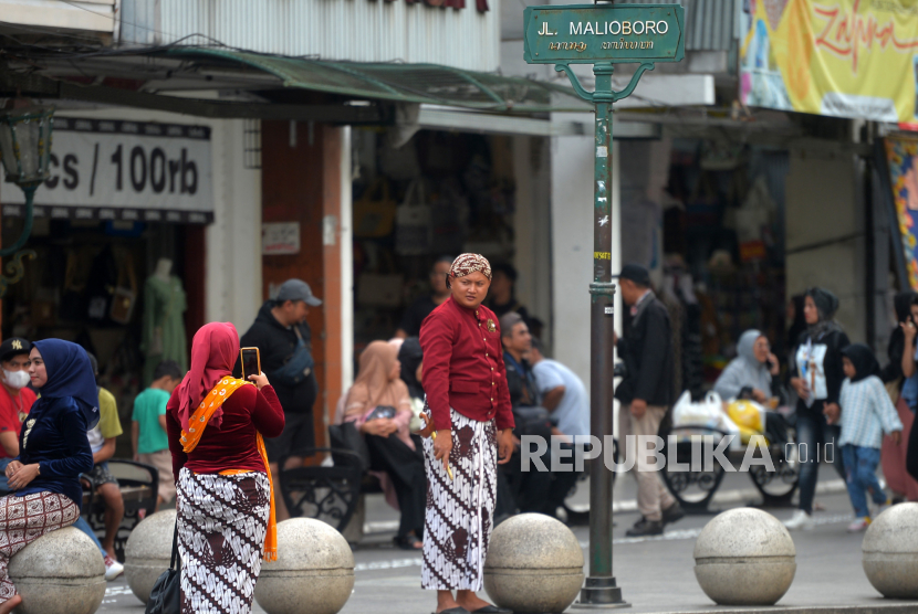 Wisatawan menggunakan pakaian tradisional adat Jawa untuk sesi foto di kawasan wisata Malioboro, Yogyakarta, Jumat (29/5/2023). 