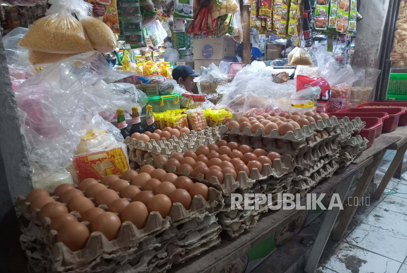 Pedagang daging ayam dan telur ayam tengah melayani konsumen di pasar.
