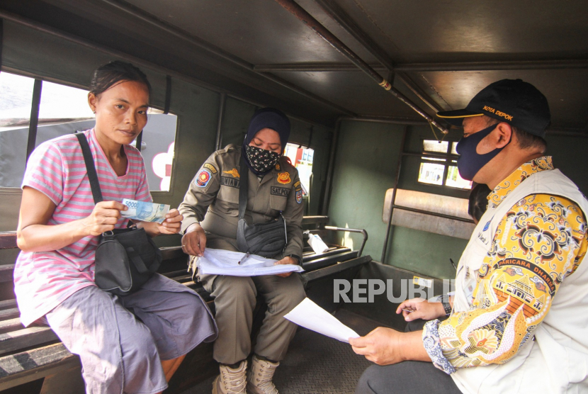 Petugas menilang  warga yang tidak menggunakan masker di Jalan Margonda Raya, Depok, Jawa Barat, Kamis (23/7/2020). Pemerintah Kota Depok menerapkan sanksi denda sebesar Rp50 ribu hingga Rp250 ribu bagi warga yang tidak menggunakan masker di tempat umum. 