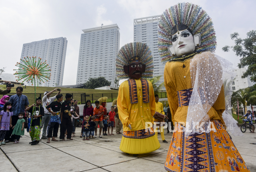 Sejumlah warga menonton penampilan ondel-ondel di Taman Ismail Marzuki, Cikini, Jakarta Pusat, Rabu (22/6/2022), dalam rangka memeriahkan HUT ke-495 Jakarta. 