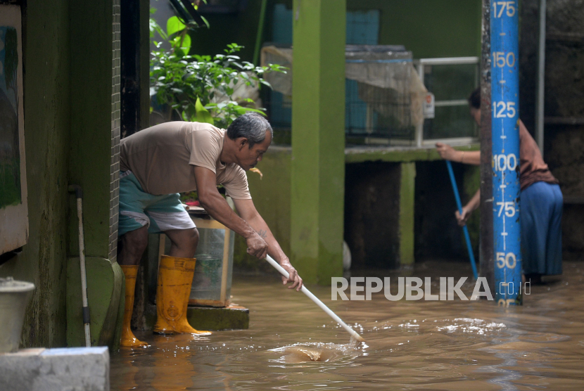 Warga membersihkan lumpur sisa banjir yang terjadi di Kebon Pala, Kampung Melayu, Jakarta.