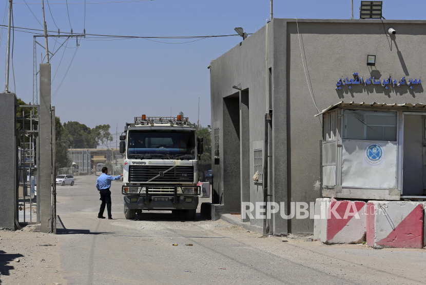  Seorang petugas keamanan Hamas memeriksa sebuah truk yang memasuki Gaza di gerbang perlintasan kargo Kerem Shalom dengan Israel, di Rafah, Jalur Gaza selatan, Senin, 21 Juni 2021. 