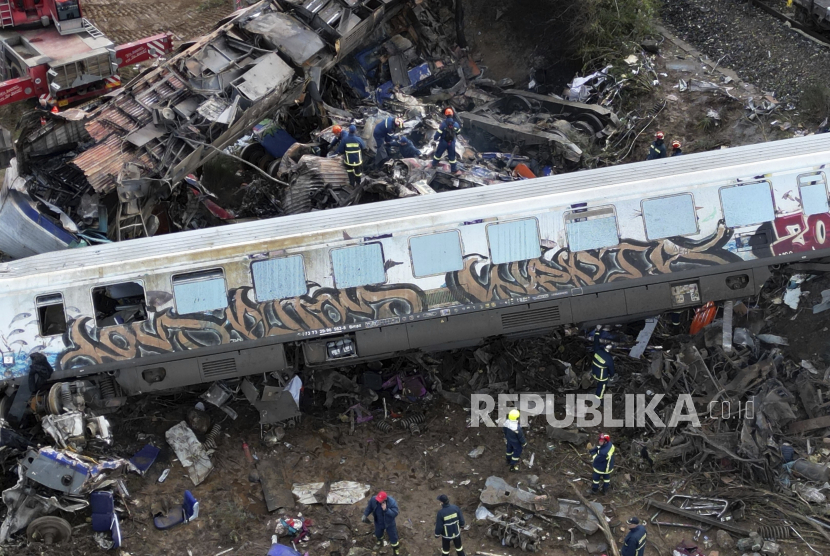  Petugas pemadam kebakaran dan penyelamat melakukan penyelamatan setelah tabrakan di Tempe dekat kota Larissa, Yunani, Rabu (1/3/ 2023.) Sebuah kereta yang membawa ratusan penumpang bertabrakan dengan kereta barang yang melaju di Yunani utara, menewaskan dan melukai puluhan penumpang.