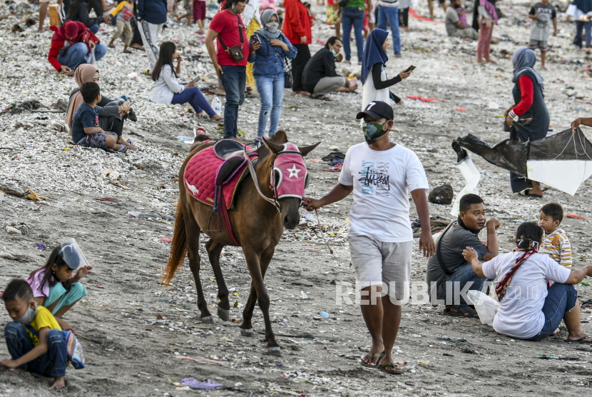 Warga menuntun kudanya yang disewakan di pesisir pantai batu-batu Kenjeran, Surabaya, Jawa Timur.