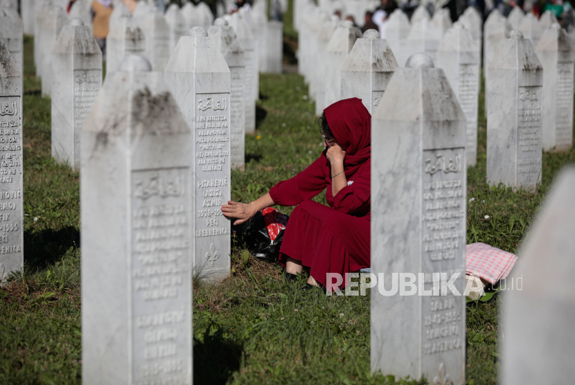  Seorang wanita Muslim Bosnia menziarahi makam selama upacara pemakaman untuk lima puluh korban Muslim Bosnia yang baru diidentifikasi, di Pusat Peringatan dan Pemakaman Potocari di Srebrenica, Bosnia dan Herzegovina, 11 Juli 2022. Pemakaman itu adalah bagian dari upacara peringatan untuk menandai ulang tahun ke-27 genosida Srebrenica, yang dianggap sebagai kekejaman terburuk dalam perang Bosnia 1992-95. Lebih dari 8.000 pria dan anak laki-laki Muslim dieksekusi dalam pembunuhan massal tahun 1995 setelah pasukan Serbia Bosnia menyerbu kota.