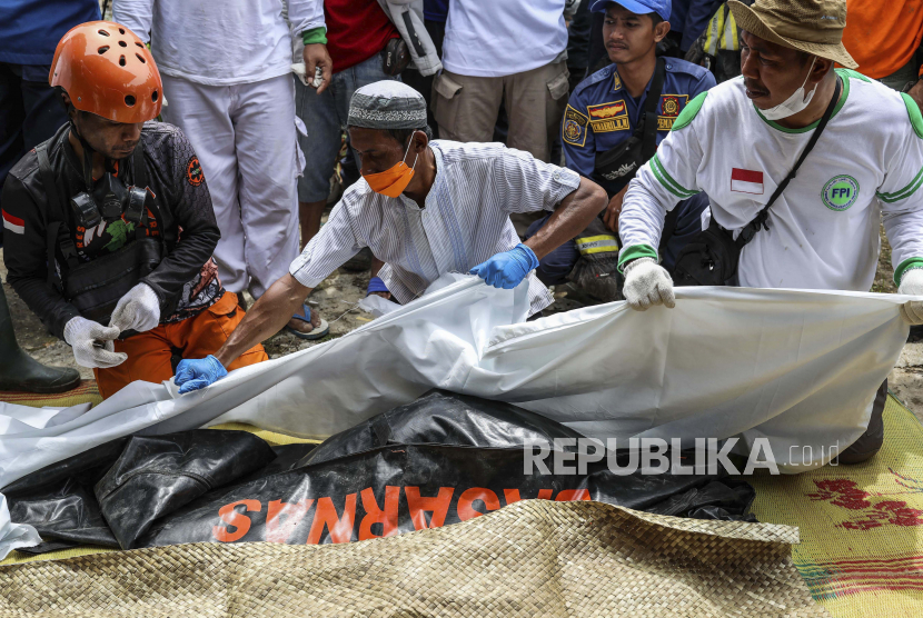 Para relawan menangani jenazah seorang gadis berusia tujuh tahun yang tewas dalam gempa Senin untuk dimakamkan, di Cianjur, Jawa Barat, Jumat (25/11/2022). Gempa berkekuatan 5,6 SR itu menewaskan ratusan orang, banyak di antaranya anak-anak , dan melukai ribuan orang.