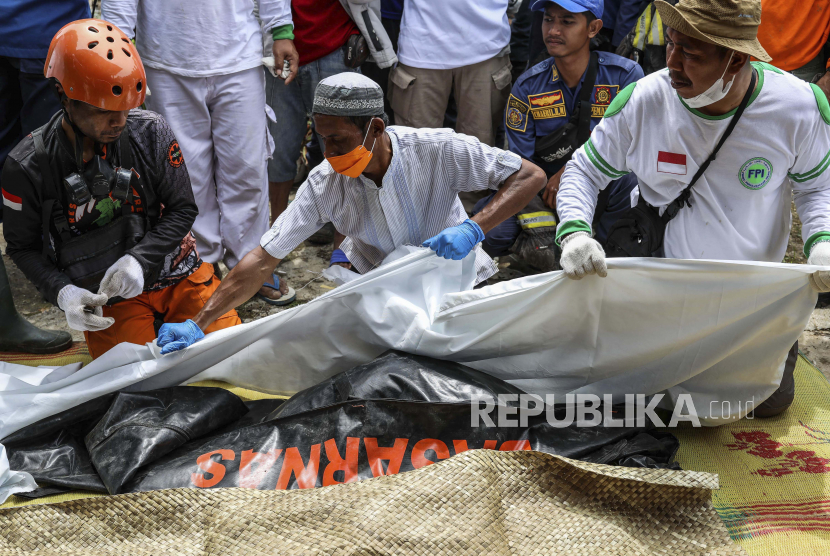  Tim penyelamat menyiapkan jenazah seorang gadis berusia tujuh tahun yang tewas dalam gempa Senin untuk dimakamkan, di Cianjur, Jawa Barat, Jumat, 25 November 2022. Jenazah dua anak dan seorang ibu korban gempa ditemukan dalam kondisi berpelukan di Desa Cijedil Kecamatan Cugenang, Kabupaten Cianjur, Jawa Barat, pada Jumat (25/11/2022) sore. 