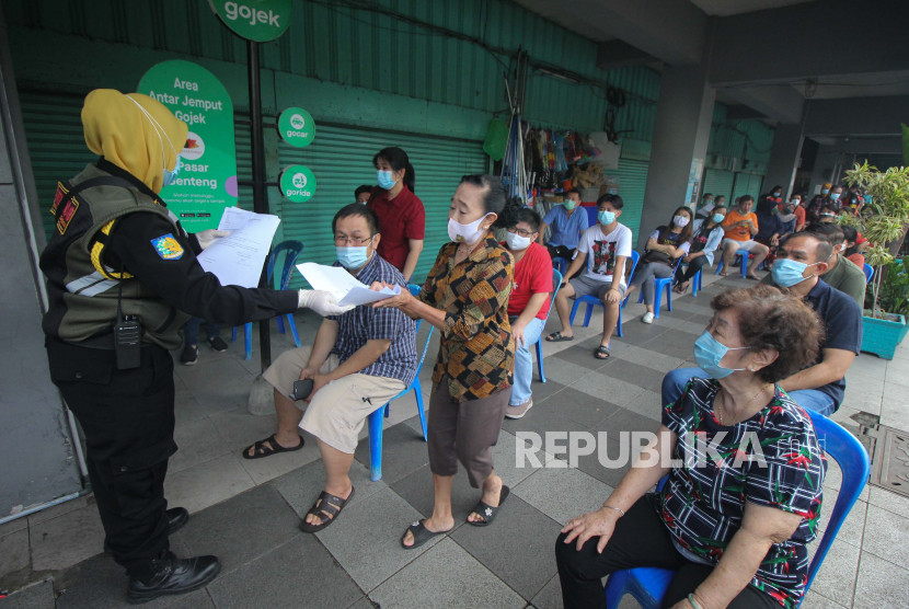 Sejumlah pedagang antre mengikuti vaksinasi COVID-19 di Pasar Genteng Baru, di Surabaya, Jawa Timur, Senin (29/3/2021). Vaksinasi COVID-19 yang ditargetkan diikuti seribu pedagang Pasar Genteng Baru serta karyawannya itu sebagai langkah penanggulangan pandemi COVID-19 