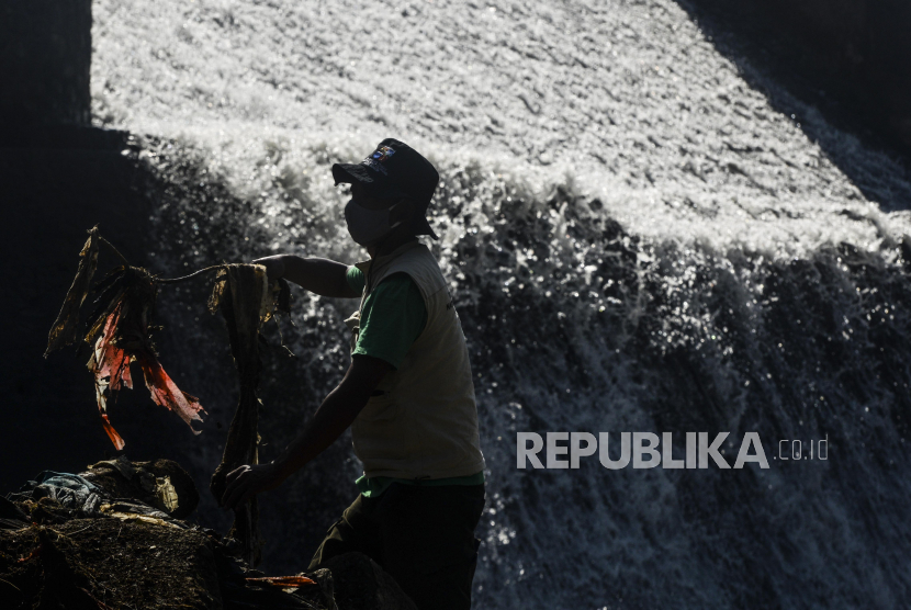 Petugas membersihkan sampah di Sungai Ciliwung, Bendung Katulampa, Kota Bogor, Jawa Barat, Kamis (16/9). Badan Penanggulangan Bencana Daerah (BPBD) DKI Jakarta mengeluarkan pemberitahuan early warning bahaya banjir pada Rabu (16/2/2022) malam.