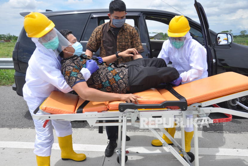 Petugas medis menggunakan APD mengevakuasi warga dengan protokol Covid-19 (ilustrasi).