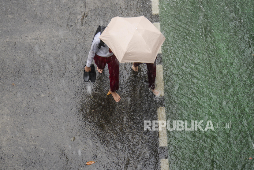 Pelajar memakai payung menerobos hujan deras di Jalan Kapten Tendean, Jakarta, Senin (7/11/2022). Curah hujan yang turun di Indonesia masuk tiga besar dunia secara densitas. Ilustrasi.