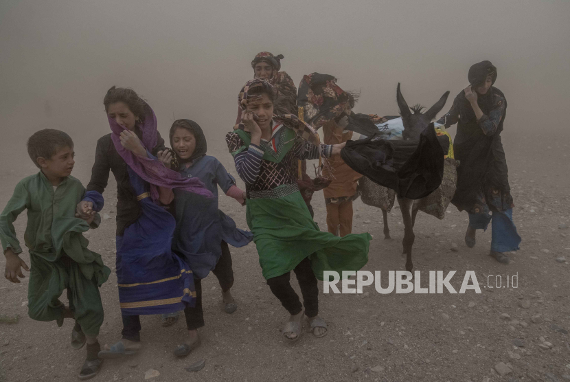 Anak perempuan dan perempuan Afghanistan membawa bantuan sumbangan ke tenda mereka, setelah gempa bumi di distrik Zenda Jan, (12/10/2023).