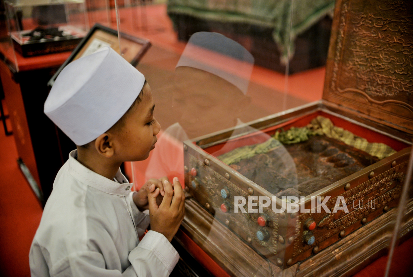 Pengunjung mengamati artefak jejak telapak kaki Rasulullah SAW yang dipamerkan di Masjid At-Tin, Jakarta, Sabtu (25/3/2023). 