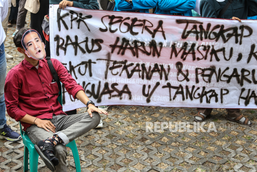 Mahasiswa yang tergabung dalam Solidaritas BEM Indonesia menggunakan topeng berwajah Harun Masiku saat aksi di Gedung Merah Putih KPK, Jakarta, Selasa (29/8/2023).