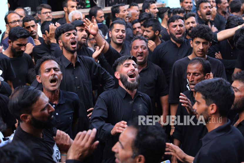 Muslim Syiah Kashmir berpartisipasi dalam prosesi pada hari kesembilan bulan Islam Muharram di pedalaman danau Dal, Srinagar, ibukota musim panas Kashmir, India.