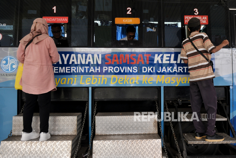 Warga mengurus berkas saat melakukan pembayaran pajak kendaraan bermotor di Pelayanan Samsat Keliling, Polda Metro Jaya, Jakarta, Senin (26/6/2023). 