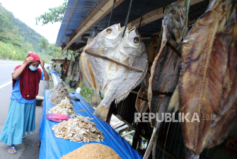  Seorang ibu memajang ikan kering olahan tradisional untuk dijual kepada konsumen di kawasan Lhok Seudu, Aceh Besar,16 Februari 2022. Produksi ikan kering merupakan salah satu upaya nelayan setempat untuk meningkatkan potensi ekonomi keluarga dengan usaha kecil di Aceh