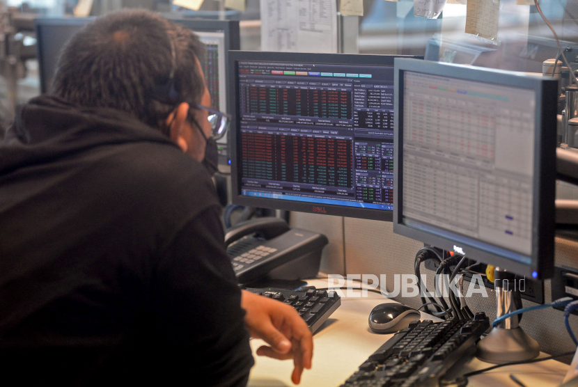 Karyawan mengamati pergerakan harga saham di layar komputer, Jakarta, Jumat (18/3/2022). BBYB, SCMA, dan AMRT direkomendasikan untuk trading hari ini.