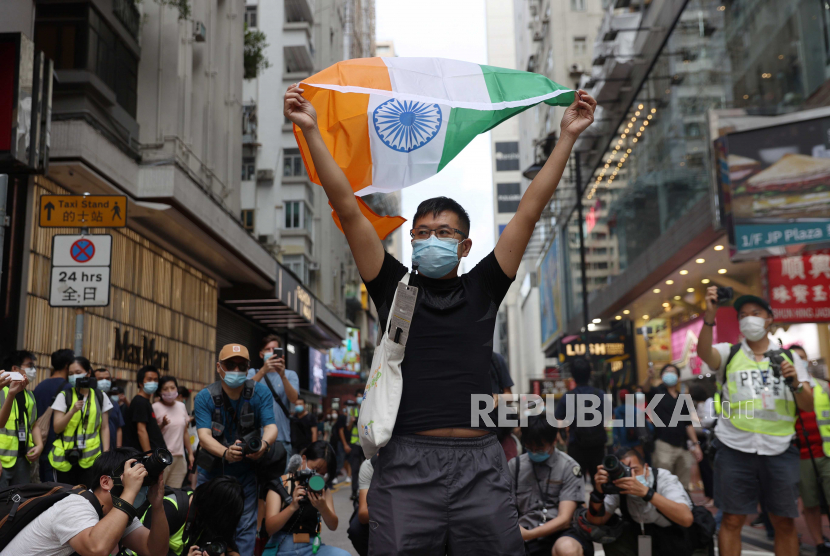  Seorang pengunjuk rasa mengangkat bendera nasional India selama unjuk rasa yang dilarang pada Hari Nasional China di Hong Kong, China, 01 Oktober 2020.
