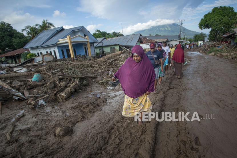 Sejumlah warga berusaha melewati jalan yang tertutup lumpur akibat banjir bandang di Adonara Timur, Kabupaten Flores Timur, Nusa Tenggara Timur (NTT), Selasa (6/4/2021). Cuaca ekstrem akibat siklon tropis Seroja telah memicu bencana alam di sejumlah wilayah di NTT dan mengakibatkan rusaknya ribuan rumah warga dan fasilitas umum. 