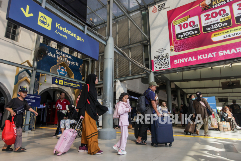 Sejumlah penumpang kereta api berjalan keluar setibanya di Stasiun Pasar Senen, Jakarta, Sabtu (13/4/2024).